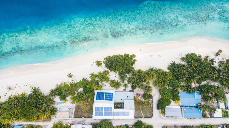 Aerial view of a rooftop PV system on a beach guesthouse in the Maldives