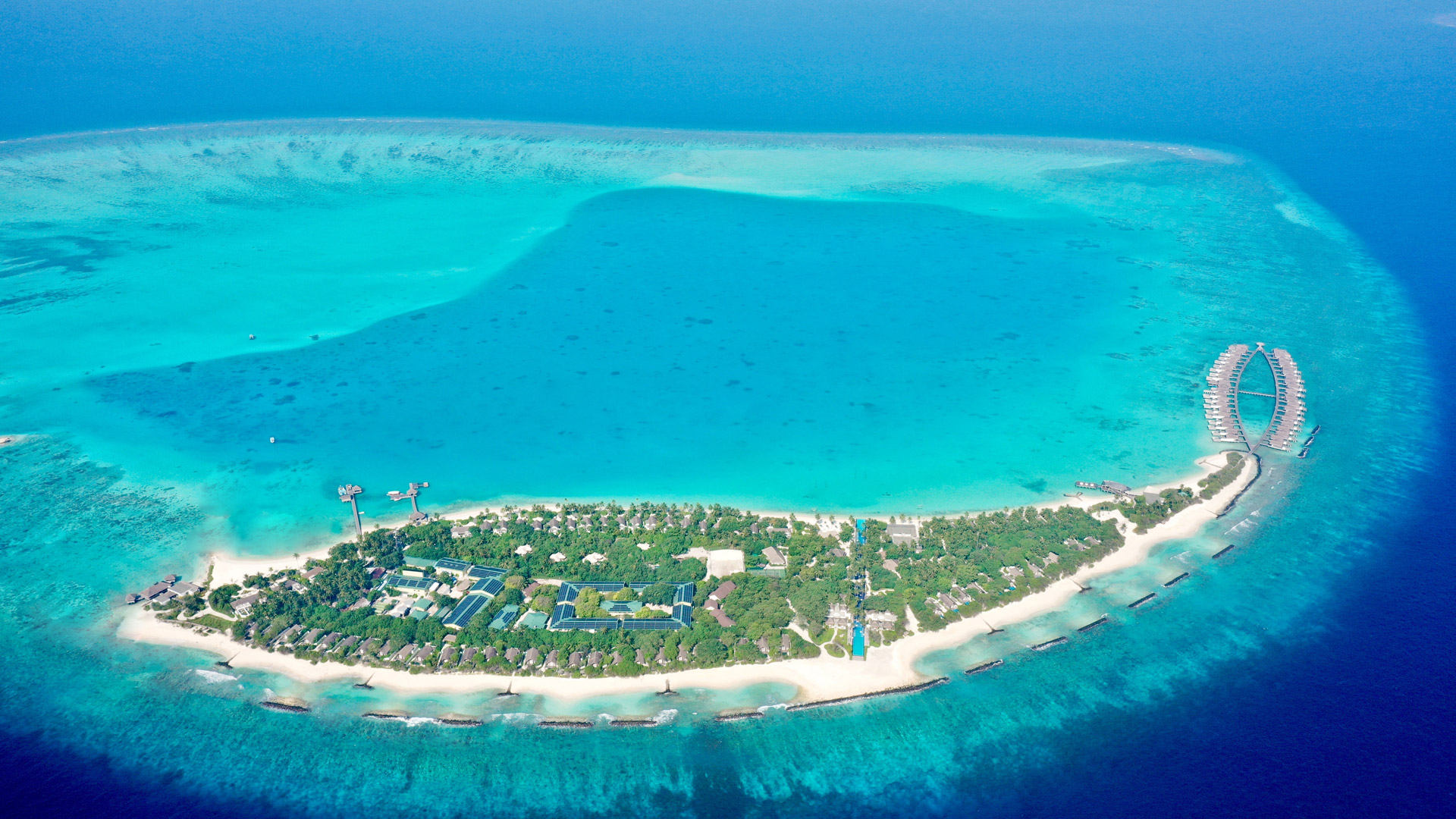 A distant aerial overview of a large scale Swimsol rooftop PV solar array at Sirru Fen Fushi Maldives